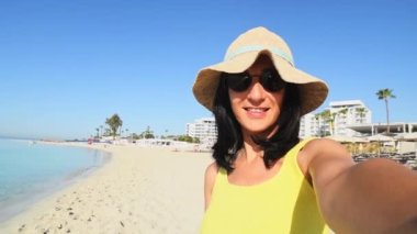 Mutlu, genç, aptal turist özçekim yapıyor tatilde sahilde poz veriyor barış parmaklarını gösteriyor - milenyum kızı kameraya gülümserken eğleniyor - insanlar ve tatil konsepti