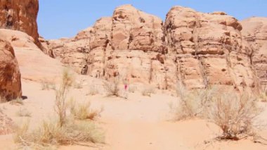 Arkaya bakan kadın turistler vadi romlu çöl manzarasını keşfederler. Ortadoğu 'da Ürdün' ün ünlü doğa koruma alanı. Ürdün bayrağını keşfedin