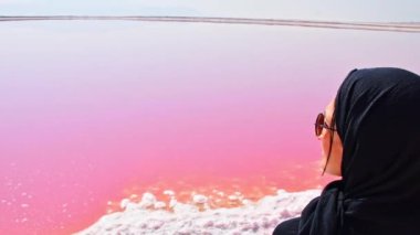 Maharlu pembe tuz gölü kıyısında beyaz kadın turist duruyor. İran 'ın Şiraz' a seyahat hedefi
