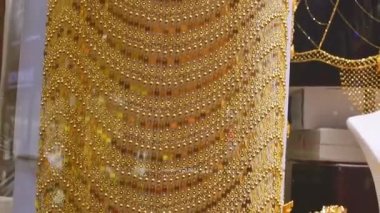 Dubai, BAE - 12 Ekim 2022: En pahalı mağaza eşyaları - eski Dubai 'deki altın çarşıda sergilenen lüks altın elbiseler ve kadınlar için kıyafetler