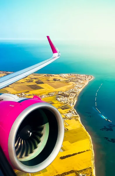 Budget low-cost airlines airlines mid-air on take-off with Cyprus island background. Flight passengers POV . Greek island summer travel destination. Vertical illustration banner