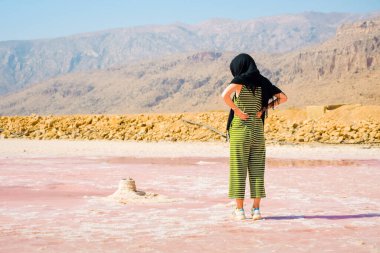Beyaz kadın İran 'ın Şiraz kentinde Maharlu pembe tuz gölü panoramasını izliyor.