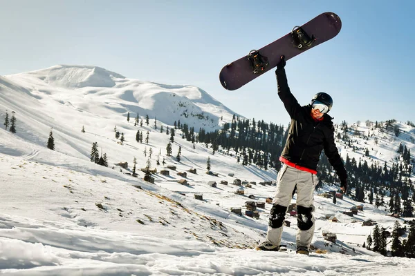 Snowboardzista Trzyma Snowboard Nad Głową Ośrodku Narciarskim Podekscytowany Wakacjami Solo — Zdjęcie stockowe