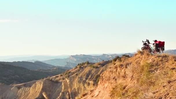ビューの空中ズームは 美しい山の背景を持つコーカサス山脈にアクセサリースタンドと赤いツーリング自転車をロードしました — ストック動画