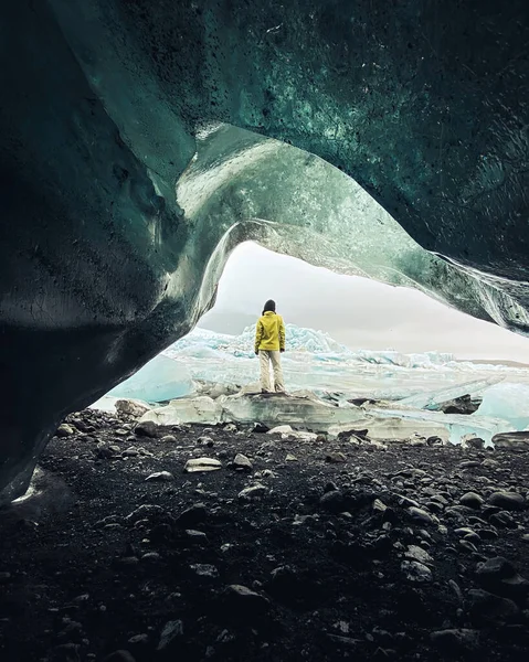 在阴云密布的日子里 冰岛的一位女游客站在美丽的冰川边 冰岛的冰洞从小缝隙洞里看 冰川附近的结构 — 图库照片