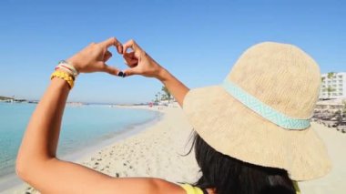 Genç ve mutlu bir turist, plajda tatil şovu otelinde poz verir. Milenyum kızı kameralara gülümserken eğlenir. İnsanlar ve tatil kavramları.