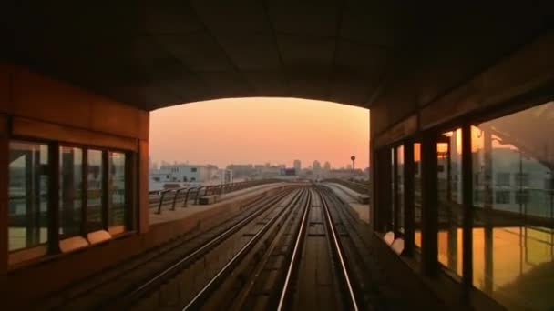 2022年10月10日 一列乘坐铁路的地铁抵达迪拜 日落橙色天空背景下的车站 — 图库视频影像