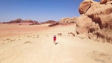 Turist yürüyüşü yapan kadın Wadi Rom 'da tatil yaparken vadi romu çöl yürüyüşü yapar. Ürdün 'de Popüler Wadi Rum Çölü