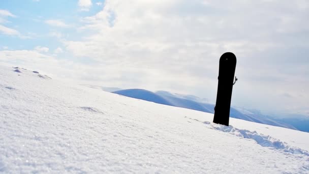 スノーボードは 冬のゴダルジスキーリゾートのトップビューポイントに美しい白い注意深い山の背景を持つ雪に立っています ジョージアスキー冬の休暇先 — ストック動画