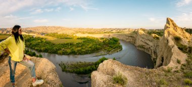 Panoramik bakış açısıyla Kafkas turist kadın gezgin uçurumun kenarında nehir ve Mijniskure manzarasıyla manzaranın tadını çıkarıyor. Georgia Azerbaycan sınırı