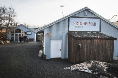 Güney İzlanda-2 Mart 2023: Fridheimar 'daki hoş geldin tabelası ve domates sera binası - ziyaretçi dostu domates çiftliği.