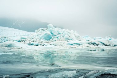 İzlanda 'da bulutlu yağmurlu bir günde Fjallsjokull buzullarını su damlalarıyla kapatın. İzlanda 'daki Fjallsrln' in muhteşem buzul gölü