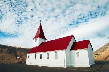 Güney İzlanda, Vik 'teki küçük kırmızı çatı kilisesini kapatın. Manzara fotoğrafçıları ve gezginleri için ikonik bir yer. Vik. Myrdal Kilisesi
