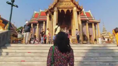 Bangkok, Tayland - 20 Mart 2024: Genç Kafkasyalı Turist Yürüyüşü Bangkok 'taki Büyük Saray tapınaklarını gezin. Tarihsel dönüm noktası yürüyüş gezisi zaman aşımı