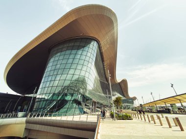 Abu Dabi, BAE - 11 Mayıs 2024: Birleşik Arap Emirlikleri 'nin Abu Dabi başkentindeki yeni Zayed uluslararası havaalanı binasının güzel dışı. Yolcular ve otobüsler kesişiyor