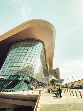 Abu Dabi, BAE - 11 Mayıs 2024: Birleşik Arap Emirlikleri 'nin Abu Dabi başkentindeki yeni Zayed uluslararası havaalanı binasının güzel dışı. Yolcular ve otobüsler kesişiyor