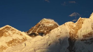 Everest ana kamp yürüyüşü. Dağ zirvesi. Everest Dağı, Lho La, Nuptse, Lhotse tepeleri. Sagarmatha Ulusal Parkı, Nepal. Açık mavi gökyüzü ve Everest Dağı manzaralı altın gün batımı