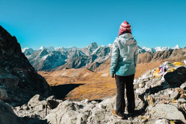 Kadın yürüyüşçü, Everest bölgesindeki Cho La Pass, Nepal 'den tepe noktasının keyfini çıkarıyor. EBC Gokyo Ri 'ye doğru yol alıyor.