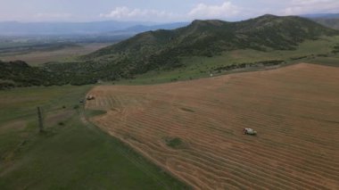 Hava manzarası yazın Georgia Kafkasya dağlarında hasat makinelerinden birini kapatıyor. Shulaveri köyü. Avrupa konseptinde mevsimlik mahsul ve tarım