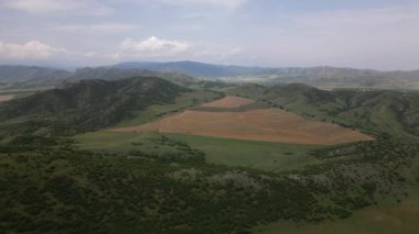 Hava panorama üç hasat makinesi yazın Georgia 'nın Kafkasya dağlarında tarla işliyor. Shulaveri köyü. Avrupa konseptinde mevsimlik mahsul ve tarım