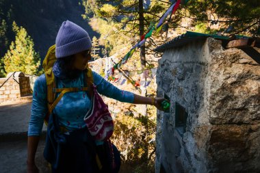 Kafkas kadın yürüyüşçü yürüyüşçüsü Himalayalar 'daki Everest ana kamp rotasındaki resmi atık noktasına plastik şişe atıyor.