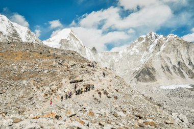 Şerpa 'lı bir grup yürüyüşçü, Sagarmatha Ulusal Parkı' ndaki EBC bakış açısına son yolculuğuna rehberlik ediyor. EBC yürüyüşü. Everest ana kampı sonbaharda yürüyor, sonbaharda güneşli havada..