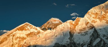 Everest ana kamp yürüyüşü. Dağ zirvesi. Everest Dağı, Lho La, Nuptse, Lhotse tepeleri. Sagarmatha Ulusal Parkı, Nepal. Açık mavi gökyüzü ve Everest Dağı manzaralı altın gün batımı