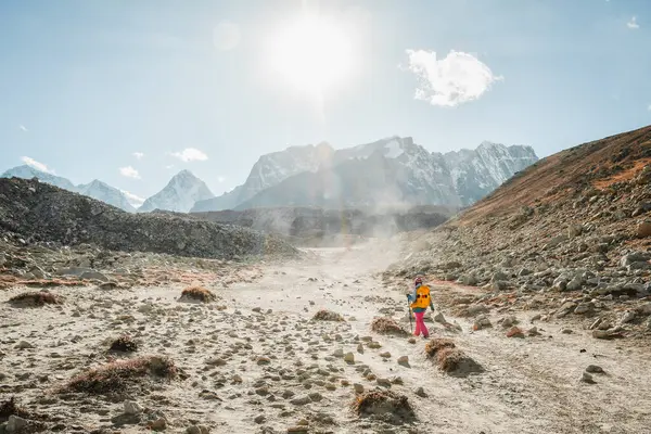 Stock image Woman trekker alone treks to EBC viewpoint in Sagarmatha national park with mountains background. EBC trekking. Everest base camp trekking in fall, autumn in sunny dry weather