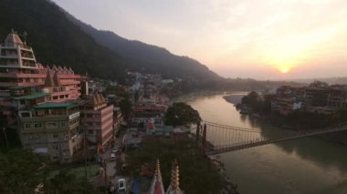 Rishikesh 'in günbatımındaki statik zaman atlaması. Hindistan' ın kuzeyindeki Uttarakhand şehrinde, Ganj Nehri 'nin yanındaki Himalaya eteklerinde.