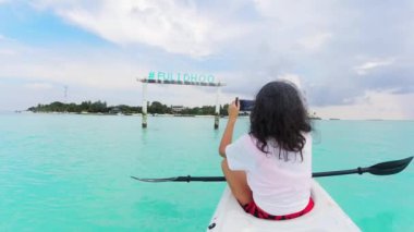 POV çifti, turkuaz tropikal sularda kayak yaparken selfie çekiyor. Maldivler 'de tatil. Fulidhoo adası kıyı şeridi ve spor faaliyetleri