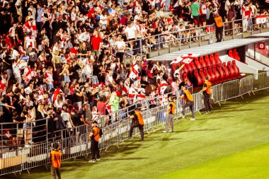 Tiflis, Gürcistan - 20 Haziran 2024: Tribün tarafından güvenlik. Georgia - İspanya maçı. İnsanlar Gürcü bayrakları sallıyor. Gürcistan Millî Futbol Takımı taraftarları stadyumda oturup EURO 2024 'ü izliyor