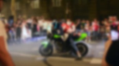 Kasıtlı olarak bulanık kopya alanı arkaplanı. Kameraman film rekor moto sporu ya da sokaktaki etkinlik izleyicilerin etrafını sardı. Gençler sokaklarda gösteriş yapar Gece gösterilerinde eğlenirler