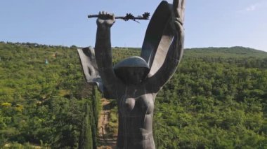 Tiflis, Gürcistan - 4 Temmuz 2024: Popüler dev Sovyet mimari heykeli. Zafer anıtı. Kollarını kaldıran ve elinde meşe yaprakları olan bir kadın.