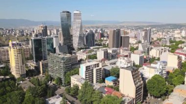 Tiflis, Gürcistan 'ın -4 Temmuz 2024: Vake ilçesindeki yükselen hava manzaralı Axis kuleleri ve şehir mülkleri ve iş binaları. Güneşli bir günde açık mavi gökyüzü olan Georgia 'nın başkenti
