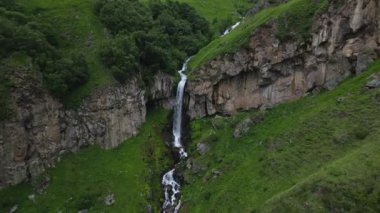 Arsha şelalesinin yeşil kafkas dağlarında olduğunu gösteren hava görüntüsü. KAzbegi Ulusal Parkı. Görecek ve yapacak şeyler. Popüler gezi gezisi eğlencesi. Gürcistan seyahat hedefi kavramı