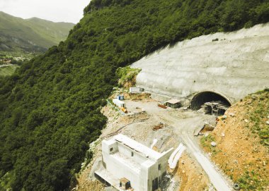 Kazbegi, Gürcistan - 7 Temmuz 2024: Çinli inşaatçılar tarafından inşa edilen yeni otoyol projesinin inşaat sahasında havadan görüş vinçleri ve köprü temel direkleri. Çığ baypas tüneli. Tbillisi - Lars