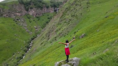 Arsha Şelalesi ve Kafkas Dağları 'nın oradaki turist kız. KAzbegi Ulusal Parkı. Görecek ve yapacak şeyler. Popüler gezi gezisi eğlencesi. Gürcistan gezisi