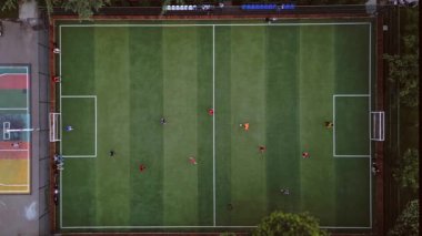Havadan aşağıya bakan iki erkek takım yeşil suni futbol sahasında futbol oynuyor. Sağlıklı spor ve çocukların yaz aktiviteleri. Georgia mı? Tiflis. Kafkaslar