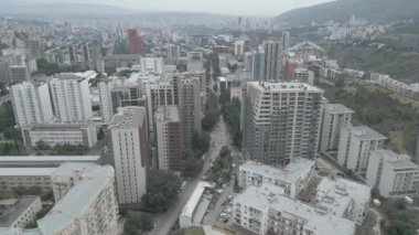 Gürcistan 'ın başkenti Tiflis' teki Saburtalo bölgesinde arabaları olan yeni modern emlak bloğu binaları çatıları ve caddelerin üzerinde uçan hava aracı. Kentleşme ve emlak geliştirme kavramı