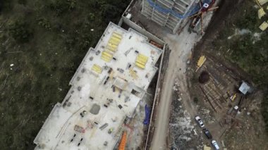 İnşaat alanının üzerinde uçan bir uçak çatıdaki bina malzemesi. Yeşil bölgedeki banliyölerde yüksek binalar var. Tiflis. Georgia mı? Kafkasya dağları emlak yatırımı