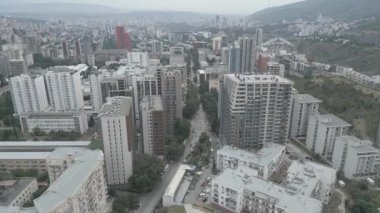 Gürcistan 'ın başkenti Tiflis' teki Saburtalo bölgesinde arabaları olan yeni modern emlak bloğu binaları çatıları ve caddelerin üzerinde uçan hava aracı. Kentleşme ve emlak geliştirme kavramı