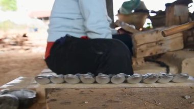 Ban Napia, Laos - 15 Ocak 2024: Laos halkı Vietnam savaşı cephanesinden ya da UXO 'dan alüminyum kaşık üretiyor. UXO toplayın, fırında eritin ve kaşıkla ev eşyalarına dönüştürün.