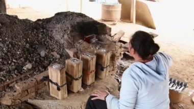 Ban Napia, Laos - 15 Ocak 2024: Laos halkı Vietnam savaşı cephanesinden ya da UXO 'dan alüminyum kaşık üretiyor. UXO toplayın, fırında eritin ve kaşıkla ev eşyalarına dönüştürün.