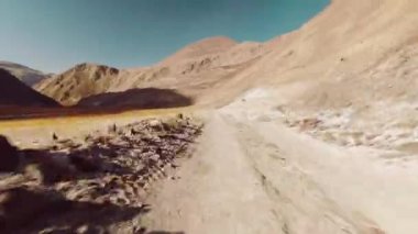 Hızlı hareket, yüksek süratli bisiklet virajı, engebeli, engebeli ve güzel Pamir dağları arka planına sahip bir yol. Pamir otobanındaki Bartang Vadisi. Gezici keşif ve seyahat kavramı