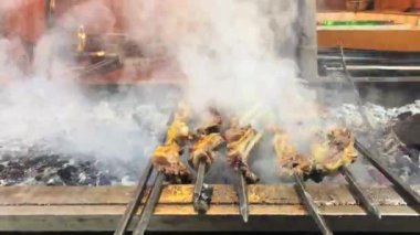 Afgan adam sokaktaki kömürlerin üzerinde kıvrılmış bbq eti hazırla. İslami beslenme. Özel et hazır. Afganistan 'da atıştırmalık ve yiyecek kavramı