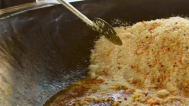Tashent, Özbekistan - 12 Ağustos 2023: Kazan kasesindeki PLOV için yakın çekim, biber, baharat ve malzemeler. Orta Asya Plov Merkezi. Başkentte popüler geleneksel restoran saklı mücevher