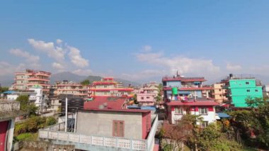 Nepal 'in Pokhara şehrindeki geleneksel Nepal yerleşim yerlerinde statik zaman atlaması manzarası. Nepal 'de konaklama ve mülk. Binaların üzerinden Annapurna dağ sıraları manzarası