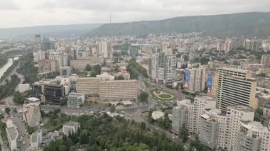 Gürcistan 'ın başkenti Tiflis' te arabaları olan modern emlak bloğu binaları çatıları ve caddelerin üzerinde uçan hava aracı. Kentleşme ve emlak geliştirme kavramı