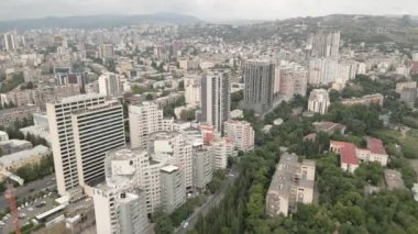 Gürcistan 'ın başkenti Tiflis' te arabaları olan modern emlak bloğu binaları çatıları ve caddelerin üzerinde uçan hava aracı. Kentleşme ve emlak geliştirme kavramı