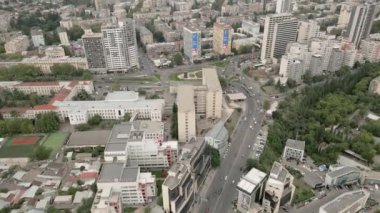 Gürcistan 'ın başkenti Tiflis' te arabaları olan modern emlak bloğu binaları çatıları ve caddelerin üzerinde uçan hava aracı. Kentleşme ve emlak geliştirme kavramı